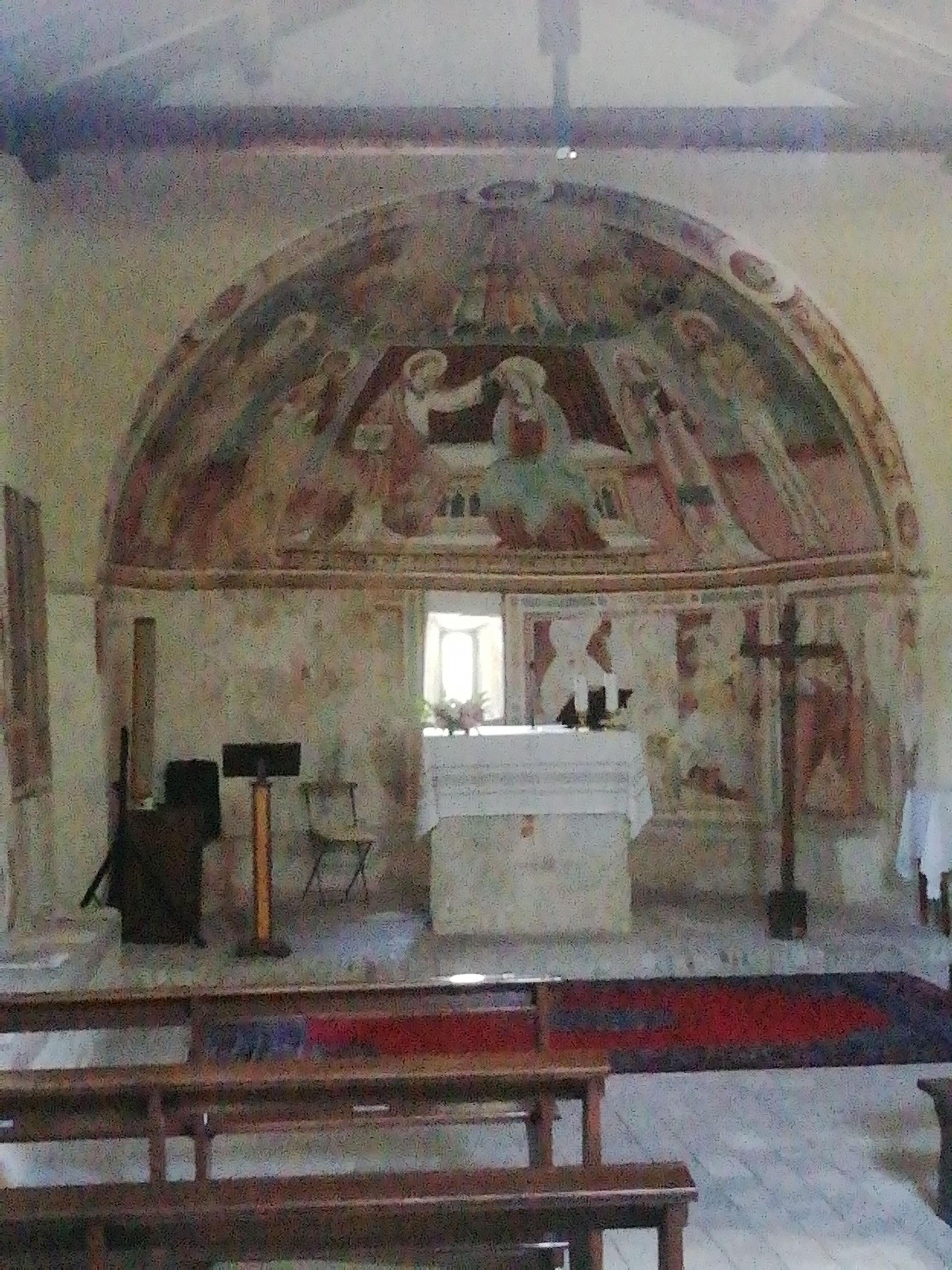 L’interno della chiesa con gli affreschi che rappresentano una processione di santi, fra cui sant’Adamo.